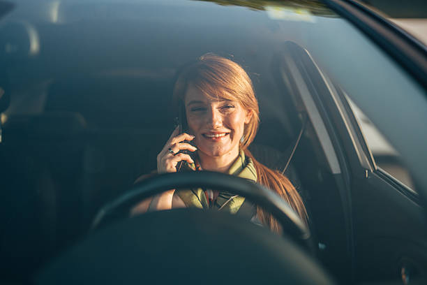 istock Businesswoman talking on mobile phone while driving car 2233838400