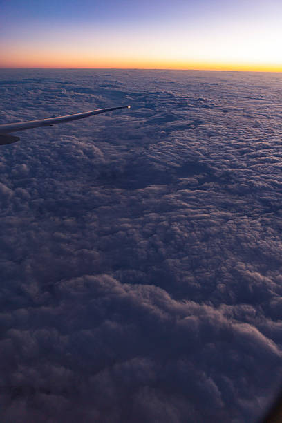 istock Airplane window sunrise view above cloud layer wingtip glowing against warm gradient sky 2233839206