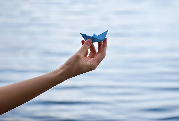 istock Paper boat on the water 2233839450