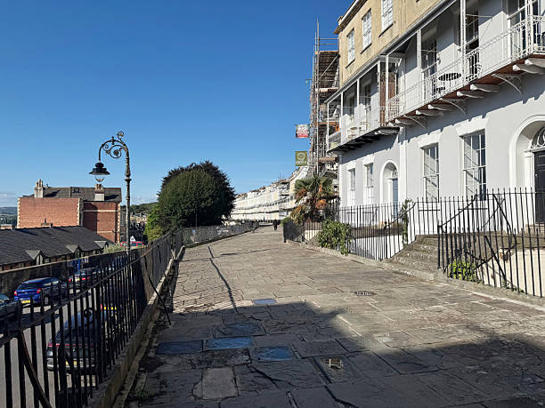 A terrace of elegant Georgian style houses with raised pedestrian walkway on Royal York Crescent in Clifton, Bristol UK September 2025