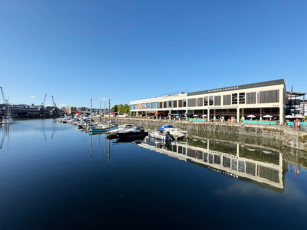 Reflection of the Ritorno Lounge and small boats in the water of Bristol Harbour on a sunny day