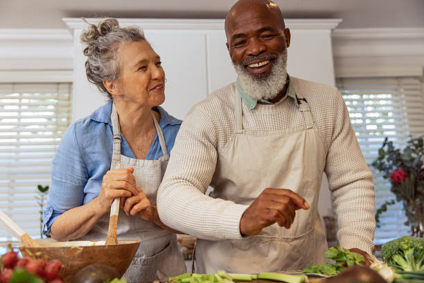 istock Mature Couple Reading Recipe from Invisible Screen – Kitchen Scene 2233840276