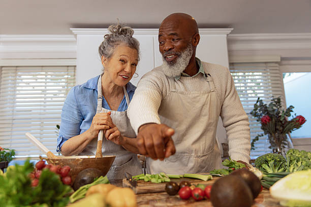 istock Mature Couple Reading Recipe from Invisible Screen – Kitchen Scene 2233840278