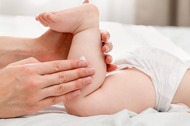 istock women's hands smear baby's feet with cream 2233841948