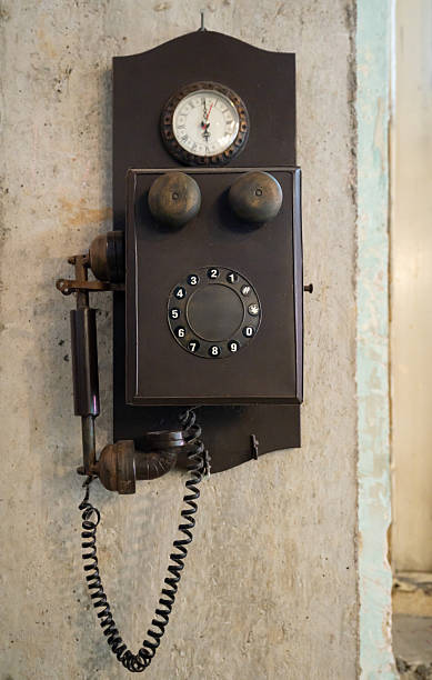 istock A nostalgic vintage looking rotary dial telephone with a clock mounted on a rustic wall, evoking timeless memories and historical charm. 2233842429