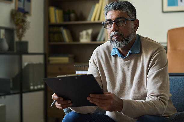 istock Middle Aged Indian Man Holding Clipboard While Listening during Meeting 2233842628