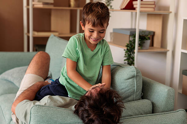 istock Father and Son Playing and Laughing on Sofa 2233845794