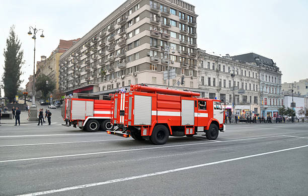 Multiple fire trucks are parked in the garage, organized in a row, showcasing their distinctive red exteriors and essential equipment