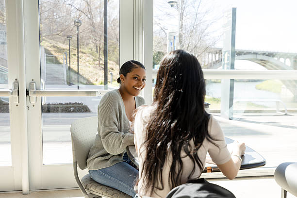 istock Two Young Women Friends Enjoying a Conversation Indoors 2233849903