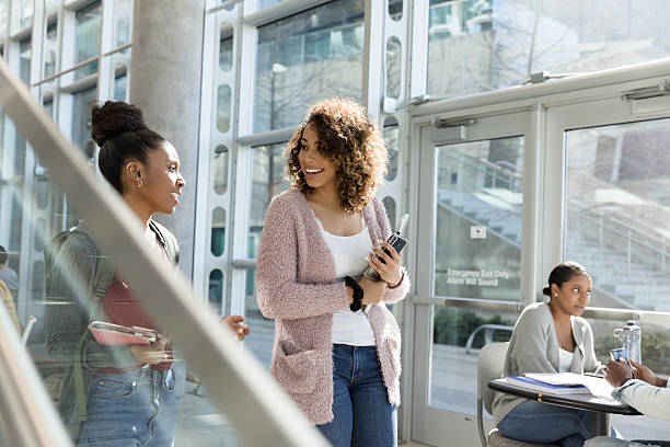 istock Multiracial students smiling, holding books and smart phones, campus 2233849980