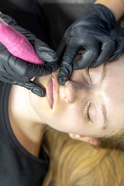 istock Lip permanent makeup application process by a skilled artist on a client in a beauty salon setting 2233854382