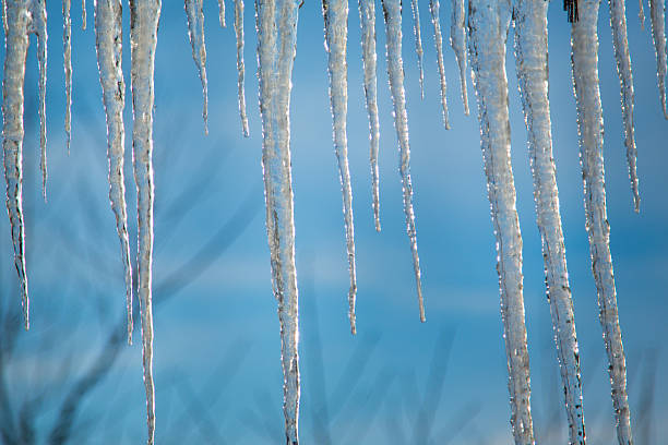 istock Large icicles close-up in sunlight against blue sky 2233856897