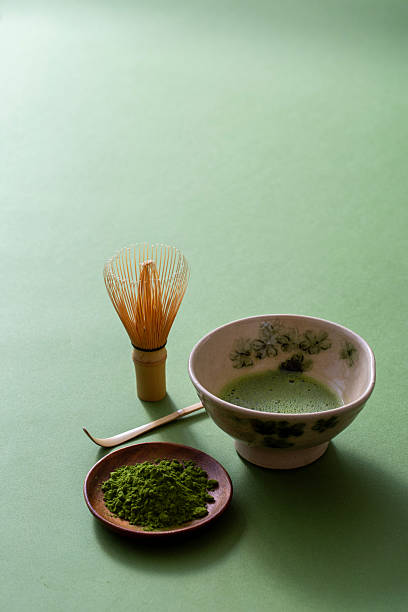 Making Japanese matcha green tea. Image of matcha green tea on a black background.