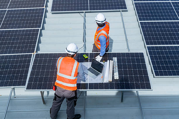 istock Solar Engineers Reviewing Installation Plans on Rooftop 2233859238