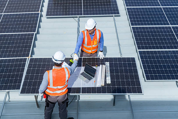 istock Solar Engineers Reviewing Installation Plans on Rooftop 2233859274