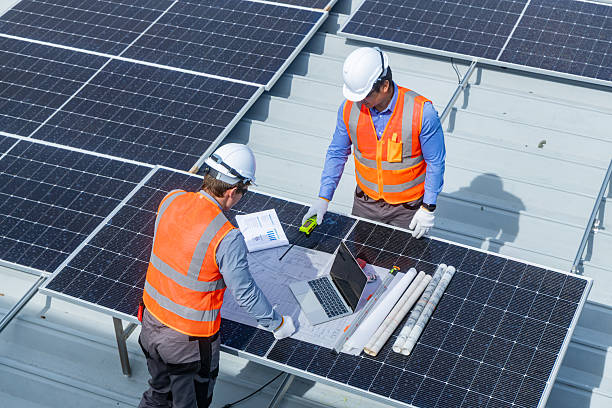 istock Solar Engineers Reviewing Installation Plans on Rooftop 2233859327