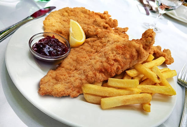 Plate with Schnitzel with French fries on white background