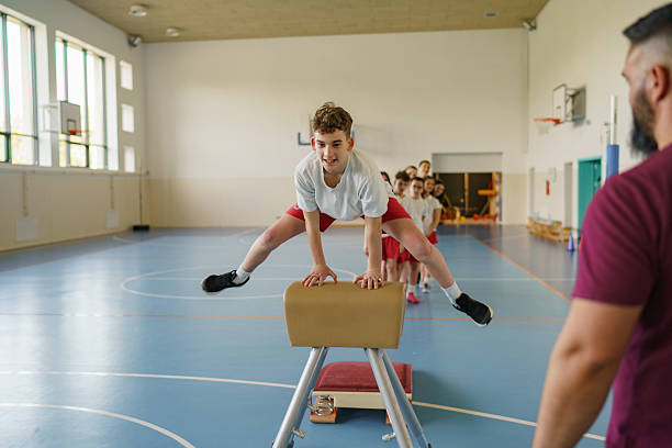 Three individuals practice balance and coordination on a beam in a gymnastics training center, showcasing focus, teamwork, and athletic skill.