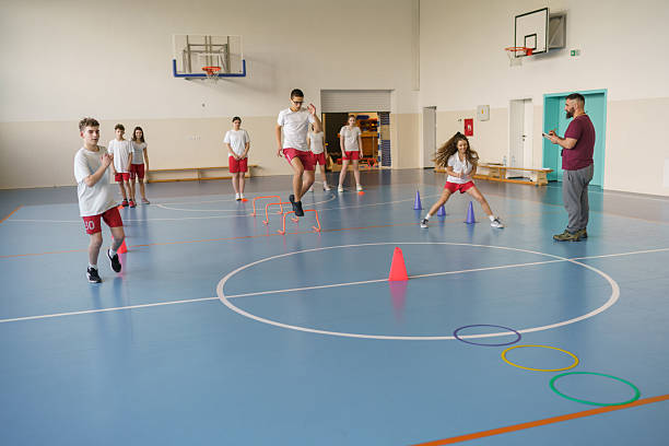 istock Students exercising with physical education teacher in school gym 2233861498