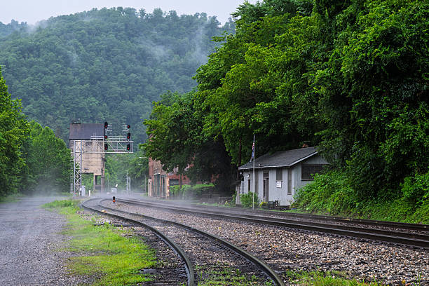 Budapest, Hungary - December 19, 2024: Misty morning view of railway tracks fading into the fog at a quiet station, creating a moody and atmospheric scene.