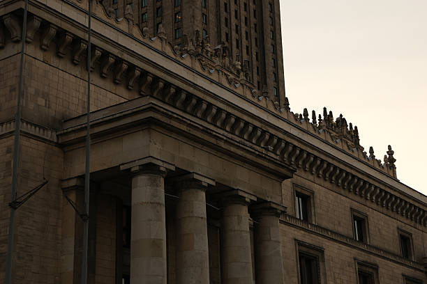 Low-angle close-up of a majestic stone building's facade, featuring classical columns and intricate detailing.  The mood is somber yet elegant, ideal for architecture, travel, or historical documentaries.  Commercial uses include websites, brochures, and print media.