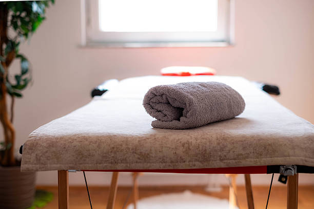 istock Rolled towel lying on a massage table in a bright room 2233871301