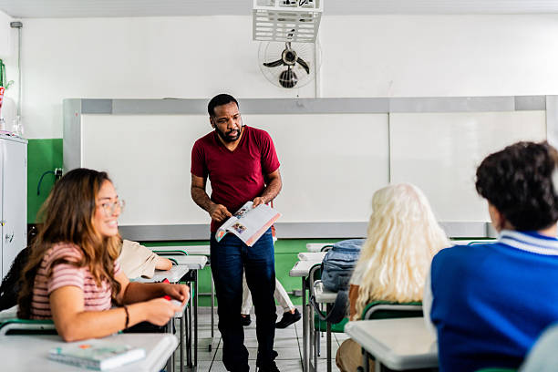 istock Teacher presenting textbook content to diverse class in classroom 2233871740