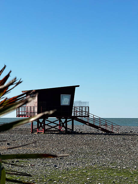 istock Lifeguard Hut on Rocky Beach with Clear Blue Sky 2233872161