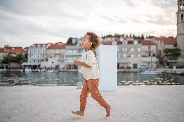 A 10 year old Caucasian girl on a wooden pier by the lake, enjoying nature.