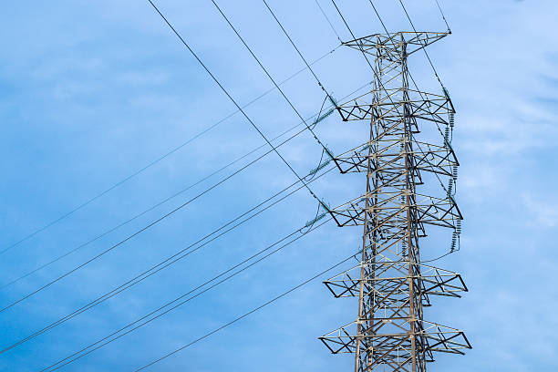 istock High voltage tower with metal structure and wires under bright sky. 2233876694