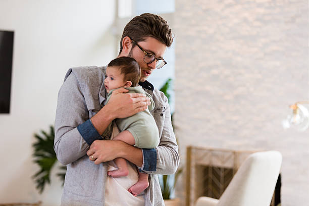 istock Young Father Gently Holding His Infant Child at Home 2233885002
