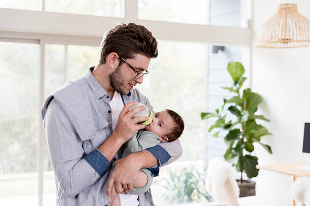 istock Father Gently Feeding His Baby Son a Bottle at Home 2233885088