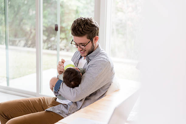 istock Happy Father Bottle-Feeding Infant Son at Home 2233885090
