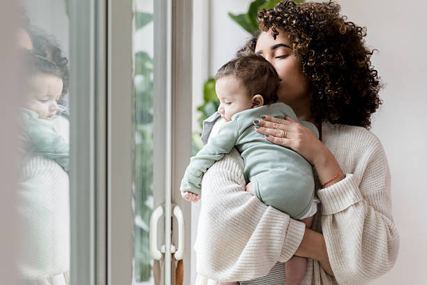 istock Mother lovingly holding her baby near a window 2233885113