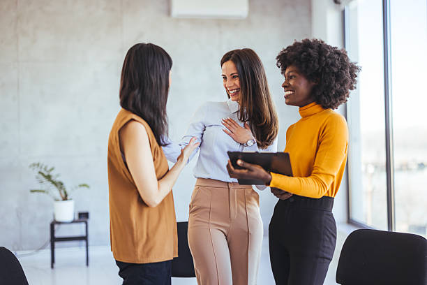 istock Diverse Coworkers Engaging in Cheerful Conversation in a Bright Office Setting 2233887066