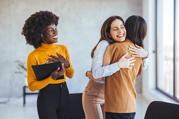 istock Diverse Coworkers Embracing and Smiling Happily in Bright Office Space 2233887092