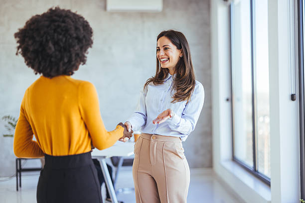 istock Two Professionals Engaged in a Warm Handshake in a Bright Office Setting 2233887156