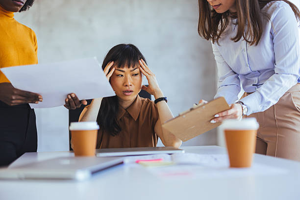 istock Stressed Business Woman Overwhelmed By Workload in Collaborative Office Setting 2233887170