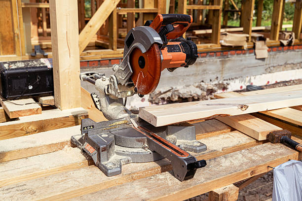 istock Carpenter using circular saw cutting wooden plank at construction site 2233891118
