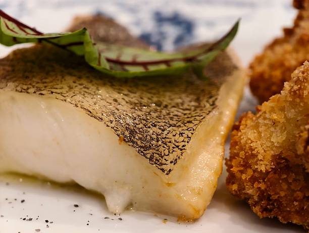 Cooked pike perch (zander) fillet, garnished with a green leaf