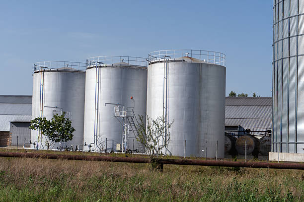 istock Grain storage silos and large warehouse hangars under clear blue sky in a rural setting 2233900143