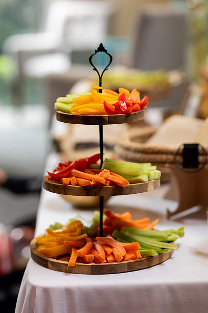 Tiered serving platter displaying colorful sliced vegetables, arranged neatly for professional catered gathering, highlighting fresh crudités selection