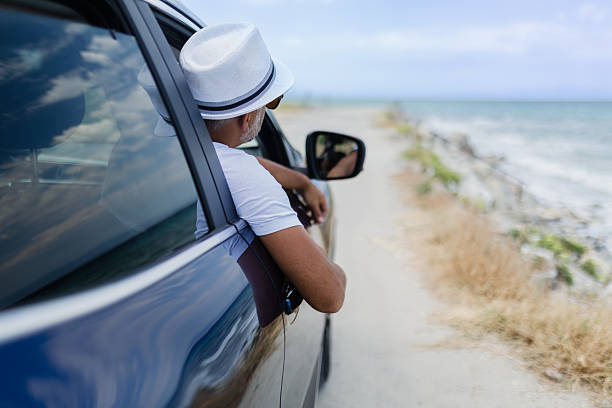 istock Man enjoying a coastal drive with a scenic view while relaxing in a car on a sunny day 2233904948