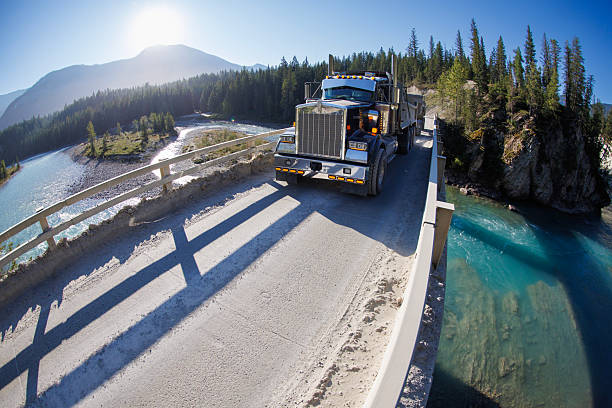 A Kenworth dump truck and trailer carrying magnesite ore from a nearby mine cross the Kootenay River near Kootenay National Park in British Columbia, Canada, on a summer's day. (John Gibson Photo / Gibson Pictures)