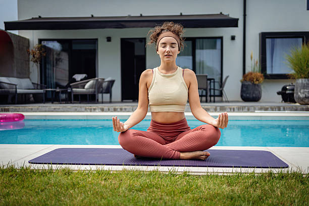 istock Woman Practicing Yoga Pose Near Poolside in Outdoor Summer Setting 2233907150