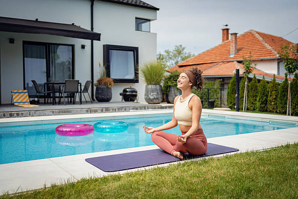 istock Woman Practicing Yoga by Poolside on a Sunny Day 2233907189