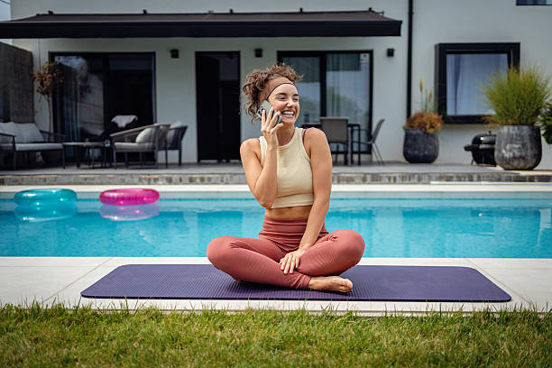 istock Woman Practicing Relaxing Yoga by a Poolside During a Sunny Day 2233907376
