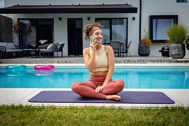 istock Woman Practicing Yoga Outdoors by the Pool on a Summer Day 2233907390