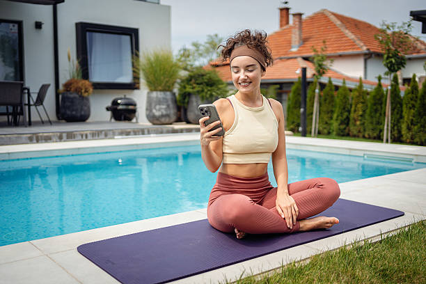 istock Woman practicing yoga outdoors beside a pool on a sunny day 2233907500