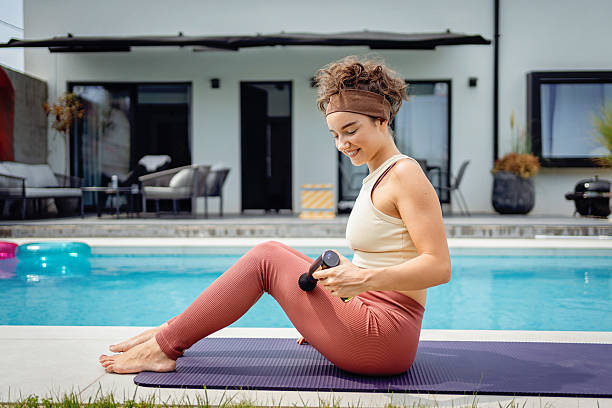 istock Young woman practicing yoga by a backyard pool in sunny weather 2233908103